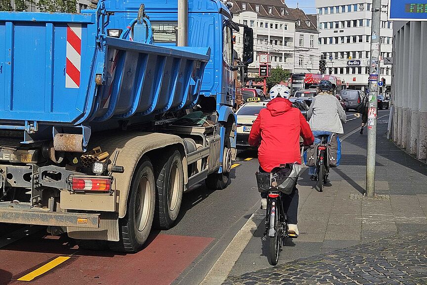 Foto eines Abschnitts der Oxfordstraße mits einem blauen Lkw und bedrängten Radfahrern , die auf den Bürgersteig ausweichen