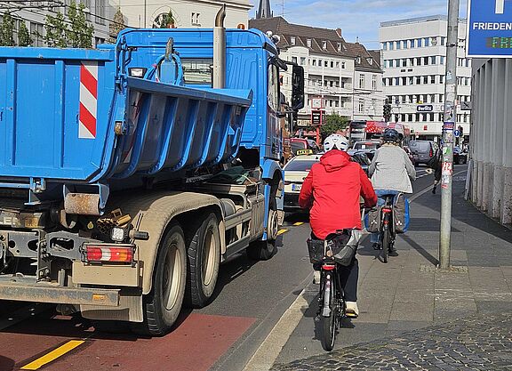 Foto eines Abschnitts der Oxfordstraße mits einem blauen Lkw und bedrängten Radfahrern , die auf den Bürgersteig ausweichen