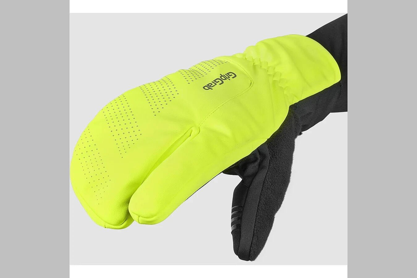 Eine Hand in einem kombinierten Fäustling und Fingerhandschuh in neongelb. 